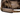 Close up of the shoulder strap of a brown duffel bag with a beige Bass Cat logo on it.
